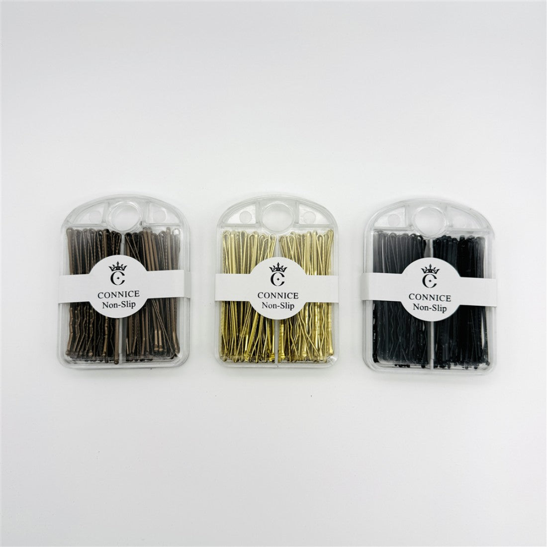 Hair pins packed in small clear plastic cases; Three colours visible: dark brown, gold and black; Front label shows brand name and non-slip text; Pins are straight bobby pin style, 6.5cm long;