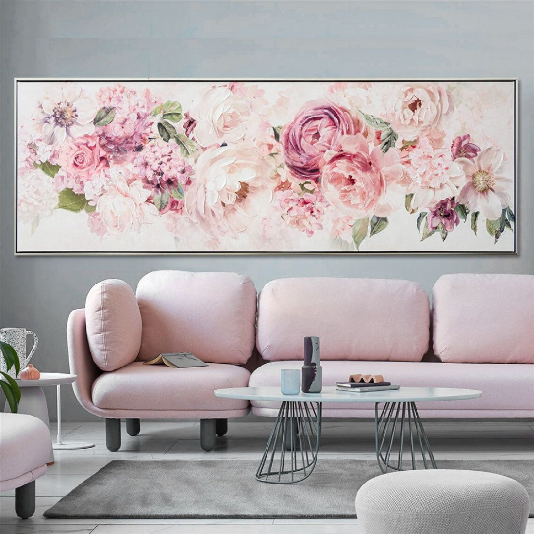 Pink and white floral design; Rectangular canvas shape; Black slim frame; Measured size 152.5x52.5 cm; Displayed in a modern living room setting;