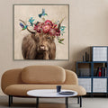 Square canvas print with silver frame; Image of brown highland cow with flower garland on head; Includes colourful flowers and green leaves; Hummingbirds depicted around the cow; Canvas size approx 102.5x102.5x4.5cm;