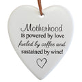 white ceramic heart shape; black printed text with mixed fonts; matte finish; brown faux-leather hanging cord;