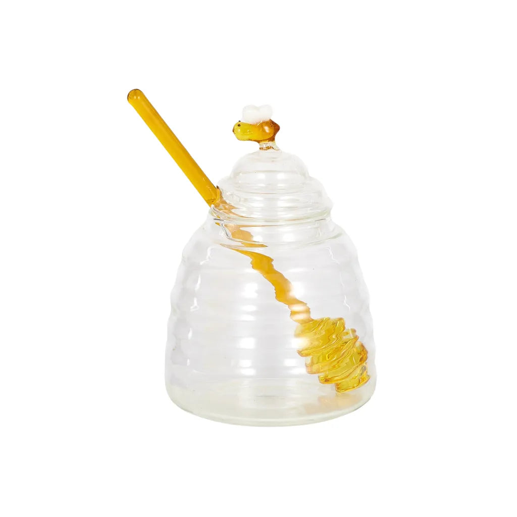 clear glass honey pot shaped like a beehive; yellow glass honey dipper included; decorative bee figurine on pot lid; compact and small size; transparent and ribbed glass design;