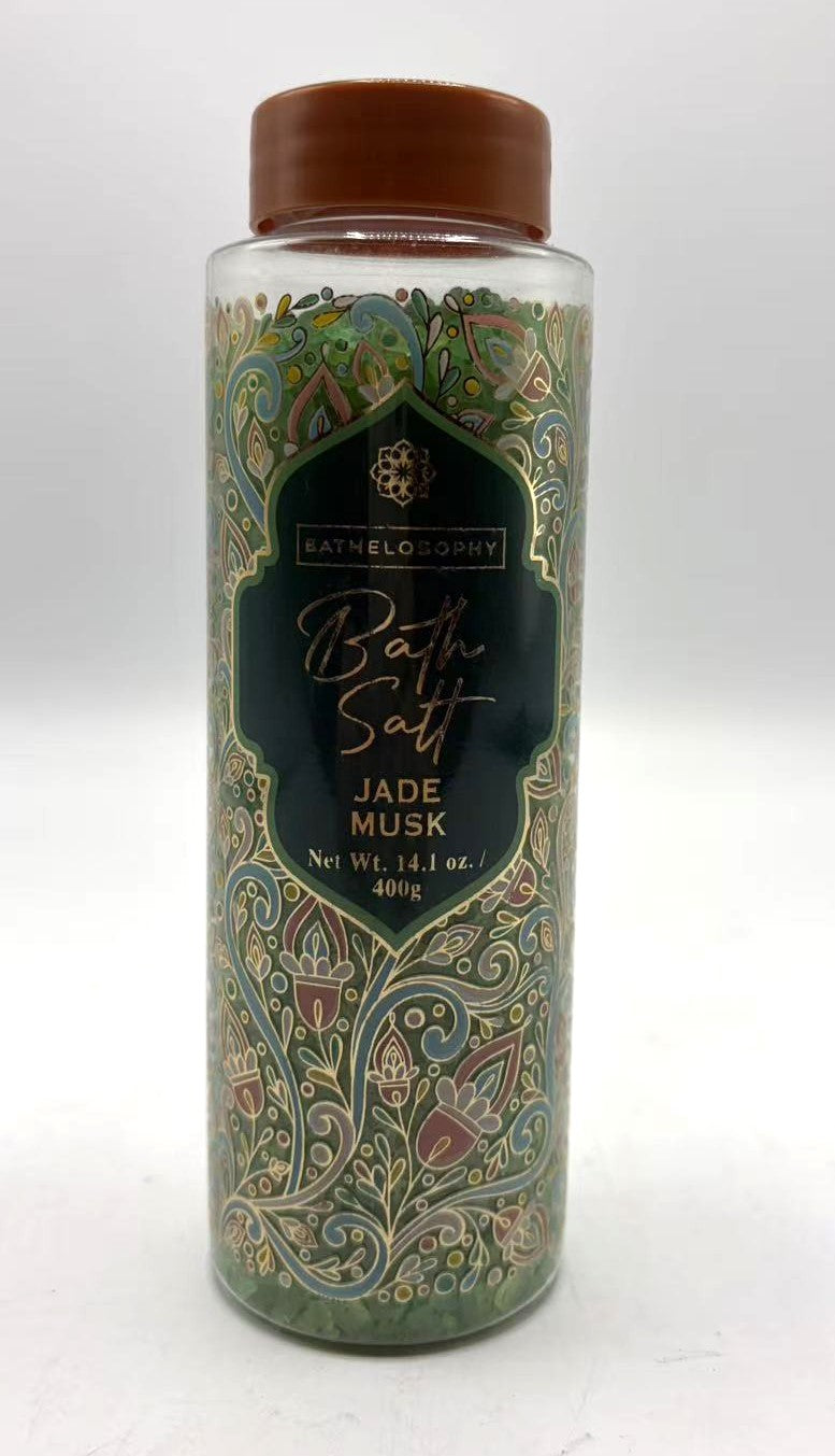 Clear plastic jar with brown screw lid; Floral and paisley decorative label design; Green bath salts visible inside jar; Label states 'Bath Philosophy Bath Salt Jade Musk'; Jar size marked as 400g (14.1 oz);