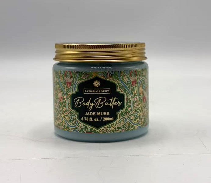 blue jar with gold lid; decorative label with floral pattern; black label with gold and white text;