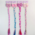 Long synthetic braids in mixed pastel and bright colours; Large glitter-covered hair bow at the top of each braid; Pearl-like beads spaced along the braids; Hair packaged on pastel purple hang cards;