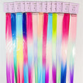 Long straight hair extensions in bright gradient colours; Mix of pink, blue, purple, yellow and green tones; Each piece packaged in clear plastic sleeve; Top header card in light pink with simple branding;