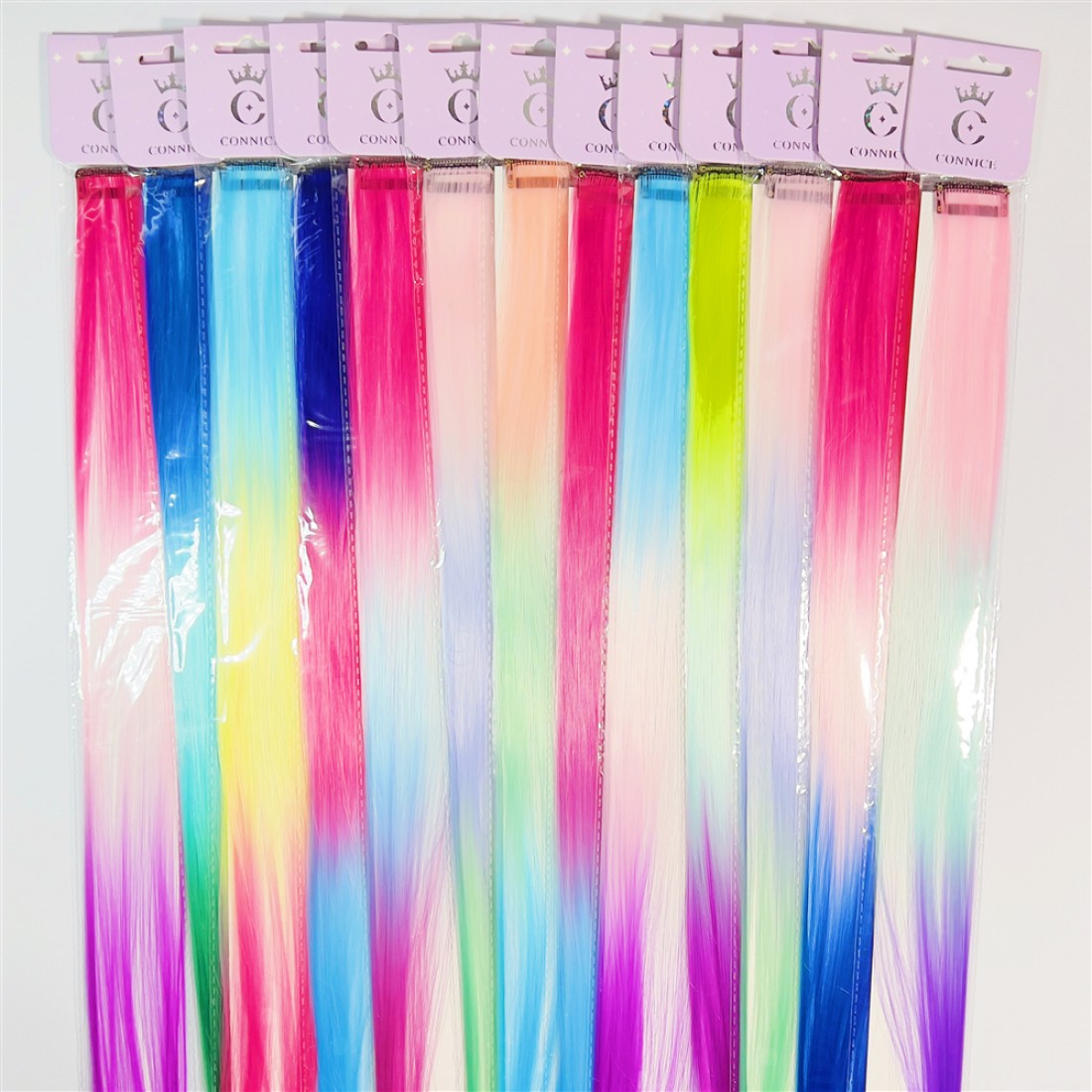 Long straight hair extensions in bright gradient colours; Mix of pink, blue, purple, yellow and green tones; Each piece packaged in clear plastic sleeve; Top header card in light pink with simple branding;