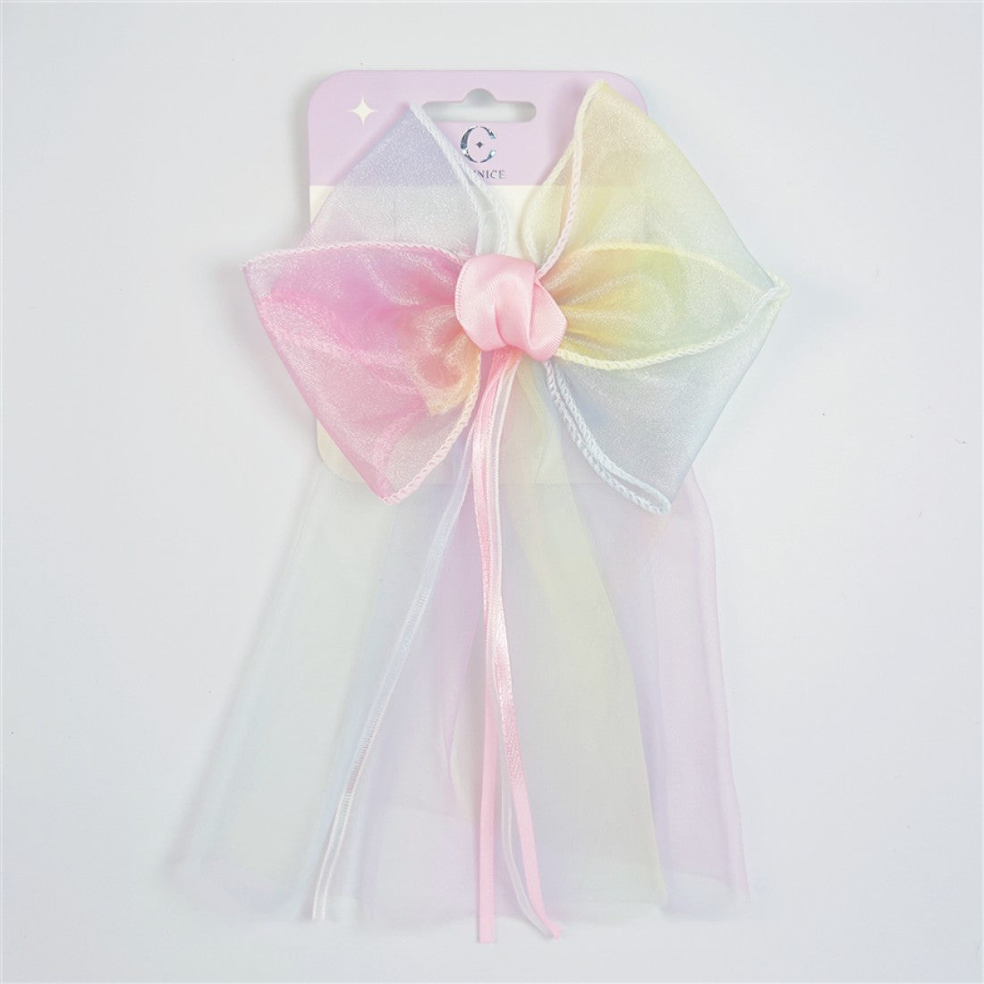 Large pastel gradient bow with pink, yellow and blue tones; Long sheer veil attached behind the bow; Pink satin knot at the centre of the bow; Thin pink and white ribbon tails hanging from the centre; Packaged on a light pink backing card;