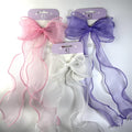 Large sheer organza bows with long wavy tails; Visible colours include pink, white and purple; Fabric has a soft shimmer finish; Edges of the ribbons are neatly stitched in matching colours; Each bow is carded on lilac branded packaging;