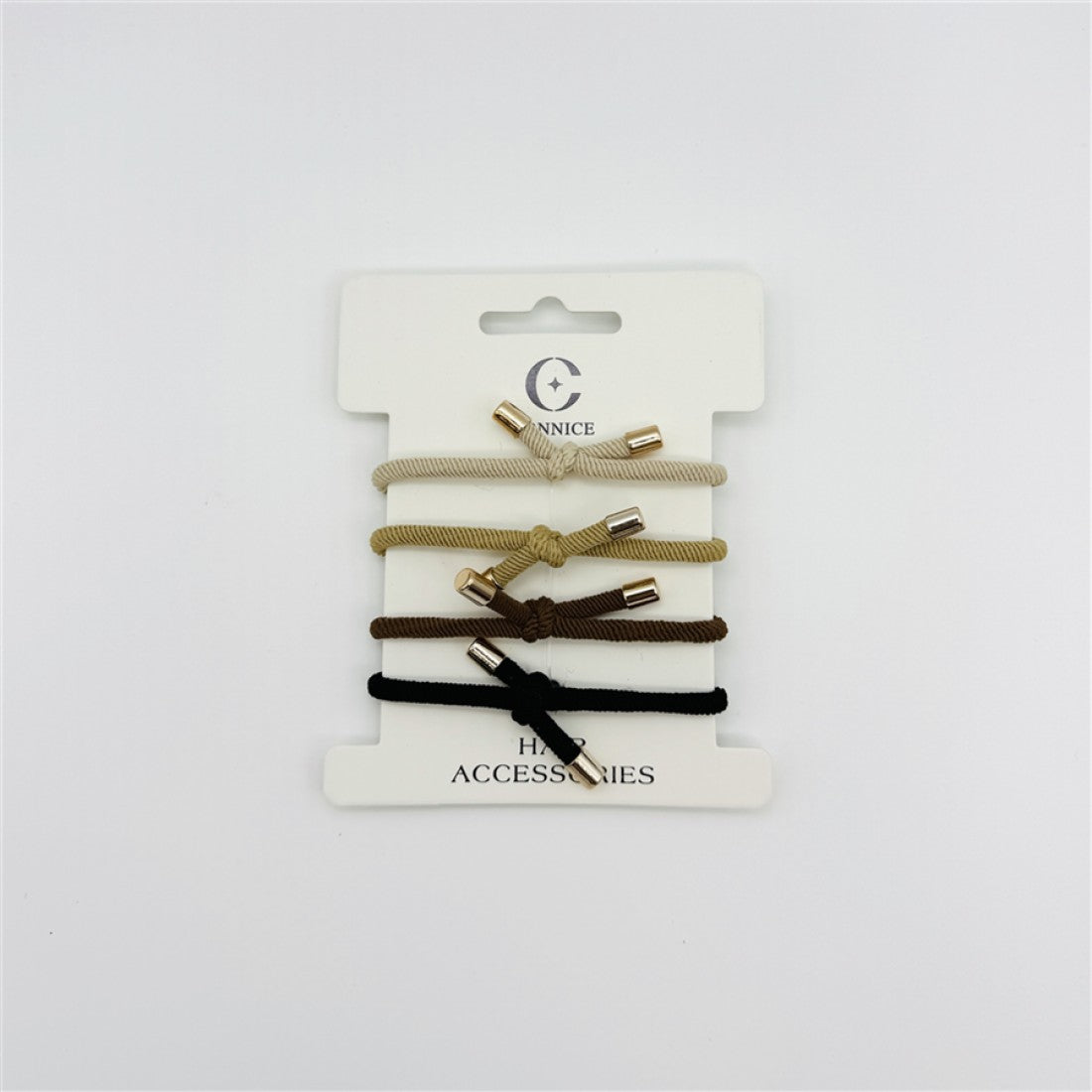 Four elastic hair ties on a white backing card; Neutral colours including beige, tan, brown and black; Knotted design at the centre of each tie; Small metallic tube ends on each tie;