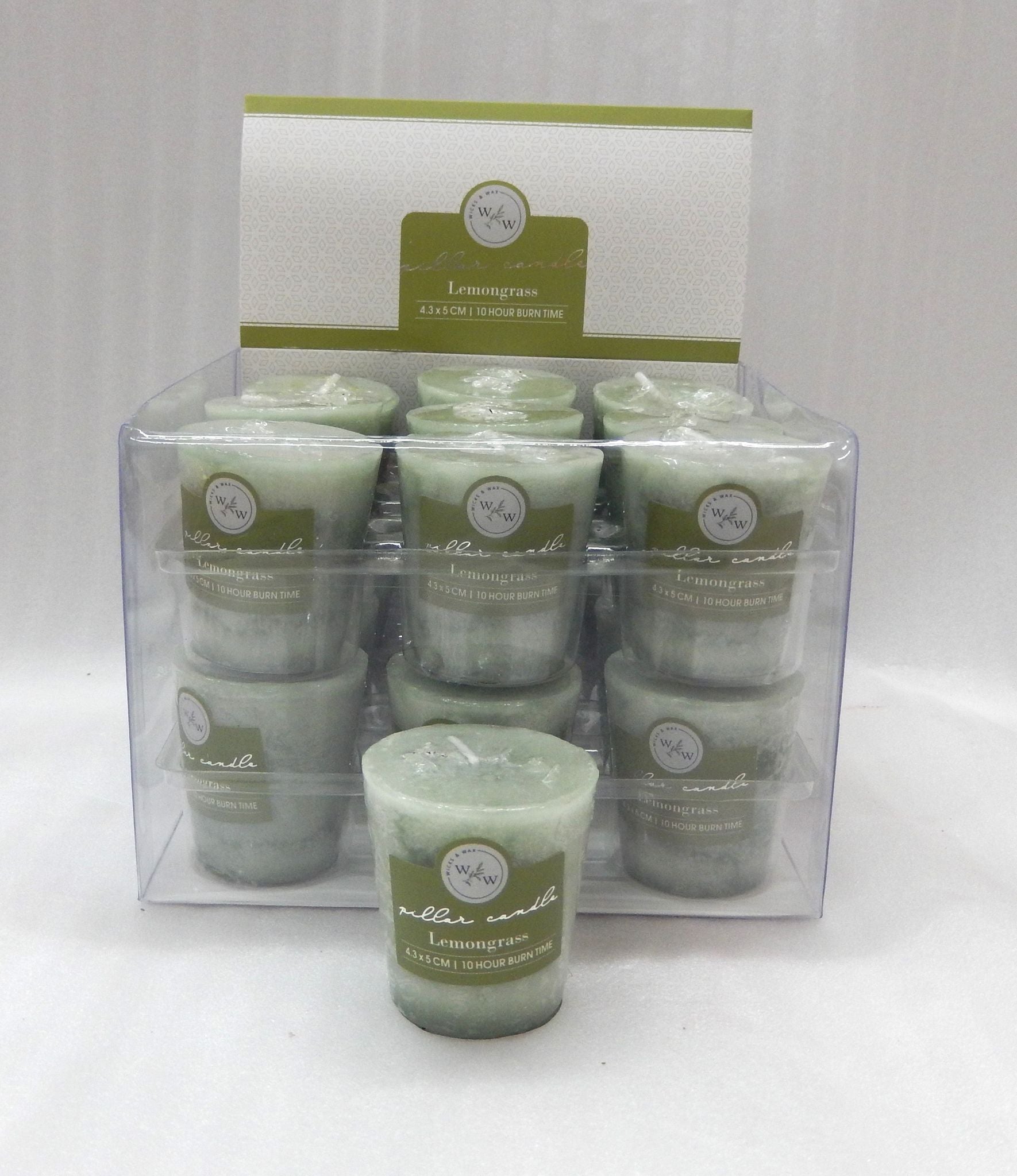 pale green solid colour candle; small votive size; label reads Lemongrass; packaged in clear plastic box; candle has wick on top;