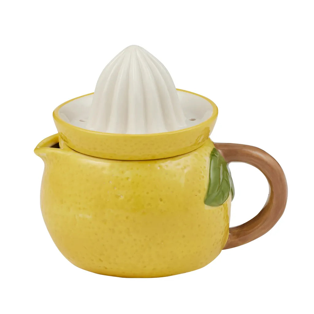 yellow ceramic body shaped like a lemon; white ceramic ridged reamer on top; brown handle attached; small spout for pouring; green leaf detail;