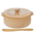 Natural beige ceramic material; Round shape with two small side handles; Fitted lid with knob and embossed lettering; Includes wooden spreader; Compact dimensions around 13.5x16x7.5cm;