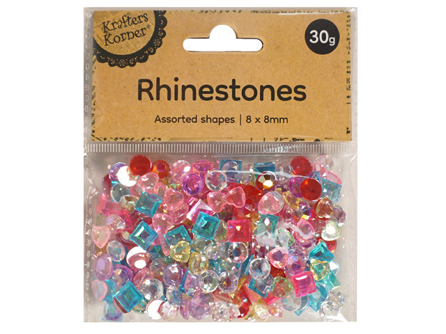 clear plastic zip-lock bag packaging; brown cardboard label with black text; assorted rhinestone shapes including round, square, heart; multicoloured stones in pink, red, blue, yellow and clear;