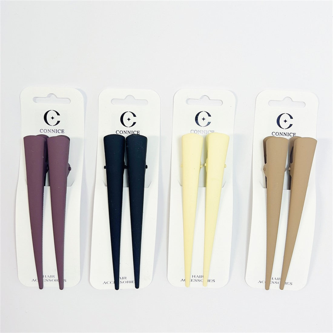 Long tapered duck-bill style hair clips; Matte finish in neutral tones (dark, cream, beige, mauve shown); Each pack contains two matching clips; Mounted on white branded backing cards;