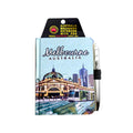 blue cover with Melbourne cityscape illustration; 'Melbourne Australia' text on cover; attached silver pen with black elastic loop; compact rectangular shape; packaged with black and yellow cardboard header;