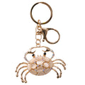 metallic gold-coloured crab shape; embellished with pearl-like stones; decorative multi-coloured small stones; includes keyring and lobster clasp attachments;