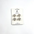 Four small flower-shaped hair clips on a branded backing card; White pearl-look beads forming each flower petal; Gold-toned metal visible at the base of the flowers; Simple white card packaging labelled as hair accessories;