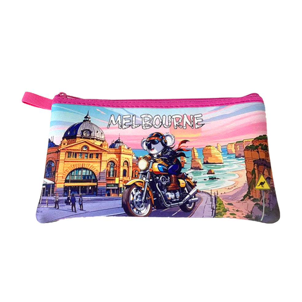 Rectangular pencil case shape; Pink zipper and pull tab; Colourful print of Melbourne landmarks; Image of koala riding a motorbike; Bright sky background with sunset colours;