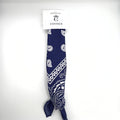 Navy blue fabric with white paisley pattern; Long rectangular bandana shape; Tied knot at one end; Cardboard hanger with Connice branding at the top;