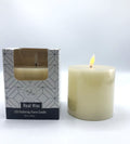 cream coloured real wax candle; cylindrical pillar shape; approximately 10cm diameter and height; flickering LED flame; packaged in white box with black geometric design;