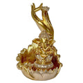 Gold-tone resin incense burner; Features a seated elephant-headed figure; Decorative bowl-shaped base with petal-like edges; Upright sculpted hand holds a small lotus-shaped holder;