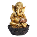 Gold-toned Ganesh statue with intricate detailing; Dark lotus-shaped base; Resin-like material finish; Small animal figure at the base near a bowl feature;