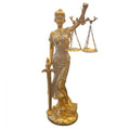 Gold-tone standing female justice figure; Holding balanced scales on chains in one hand; Sword held downward in the other hand; Detailed flowing robe and blindfold; Stands on a sculpted base with books;