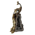Gold and silver peacock figurine with detailed feather patterns; Green accents on tail feathers; Mounted on a geode-style base with crystal-like texture; Tall, narrow decorative ornament proportion; Metallic and stone-like finishes;