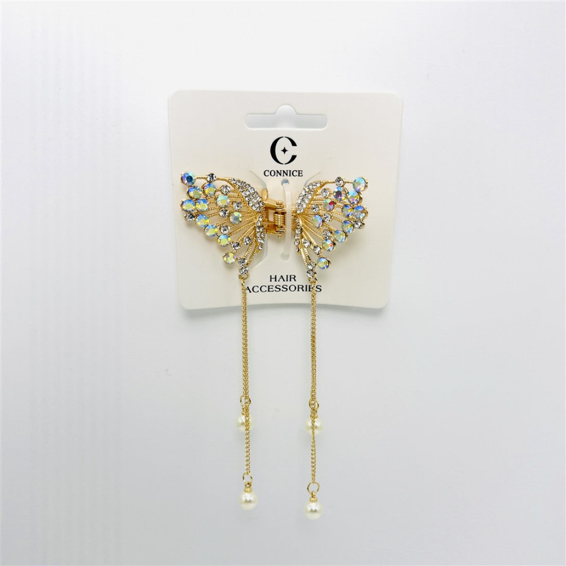 Gold-tone butterfly-shaped claw clip; Wings decorated with iridescent rhinestones; Two long gold chains hanging from the clip; Pearl-like beads at the ends of the chains; Mounted on branded hair accessories card;