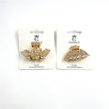Gold-tone metal claw hair clips; One clip shaped like a butterfly with rhinestones; One clip shaped like a leaf with rhinestones; Packaged on white backing cards branded "CONNICE";