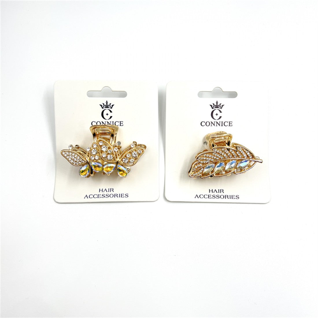 Gold-tone metal claw hair clips; One clip shaped like a butterfly with rhinestones; One clip shaped like a leaf with rhinestones; Packaged on white backing cards branded "CONNICE";