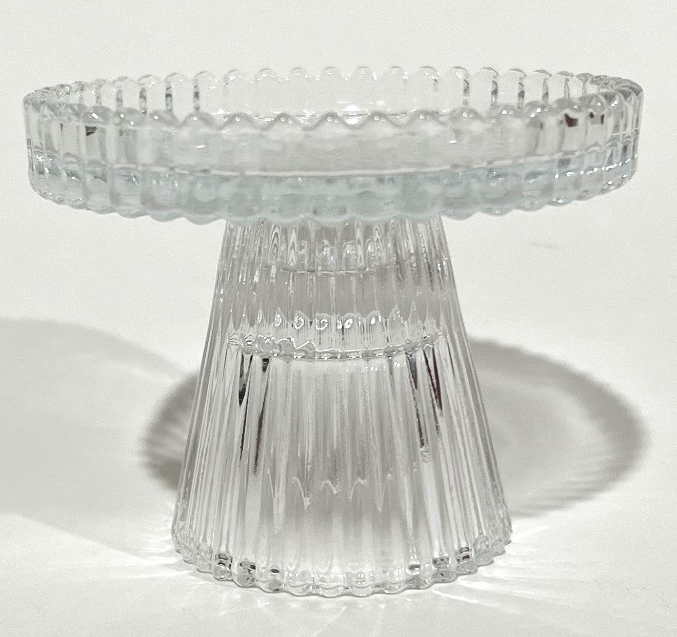 clear glass material; ribbed texture on surface; round top surface; short pedestal base; compact size;