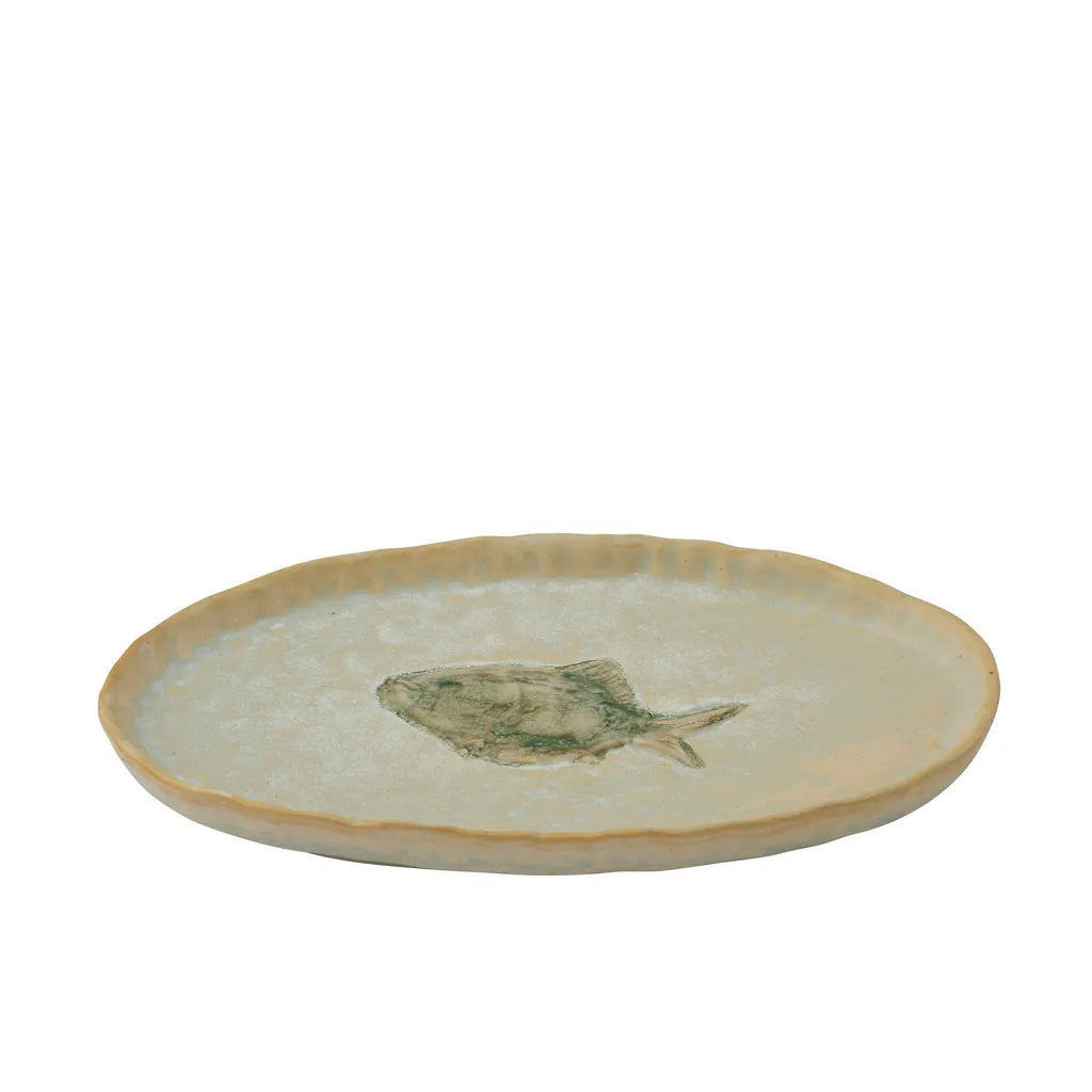 Ivory coloured ceramic plate; Green fish motif in centre; Irregular rounded shape; Glazed ceramic surface;