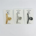 Slim metal hair claw clip in a cross-like rose shape; Set shown in metallic gold, silver and dark grey finishes; Clips presented on white branded backing cards; Text on card reads “HAIR ACCESSORIES” at the bottom;
