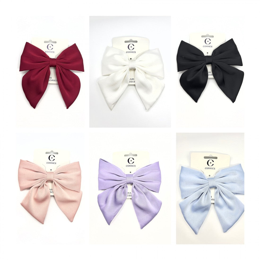 Large satin fabric bow with long tails; Shown in multiple solid colours including red, white, black, pink, lilac and light blue; Mounted on branded backing card labelled as hair accessory; Soft, slightly shiny fabric texture;
