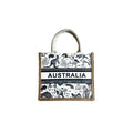 white and black animal print with Australian wildlife; natural jute border on bag edges; white fabric handles; rectangular shape with snap button closure;