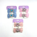 Each card shows a pair of fabric hair bows; Bows come in pastel blue, pink and peach shades; Large central coloured gem set in silver snowflake; Mounted on purple and white display cards;