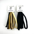 Two hanging card packs each holding six fabric-covered hair ties; One pack in assorted beige and brown tones; One pack in solid black; Flat, thick, tubular band design; Simple white header card with brand text and crown logo;