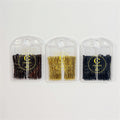 Three clear plastic cases each holding 50 U-shape hair pins; Pins visible in brown, gold and black colours; Round hanging hole at top of each case; Gold circular logo and text printed on front of cases;