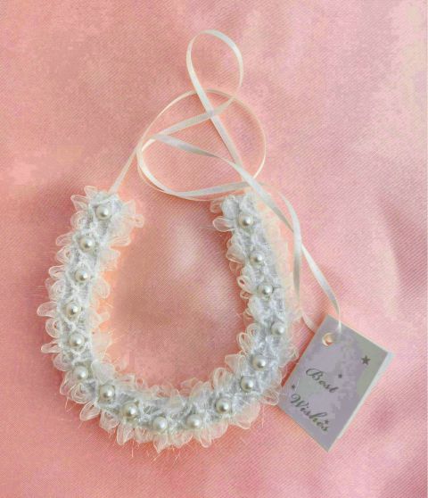 white lace with scalloped edges; pearls aligned along band; thin white ribbon tie; soft sheer fabric appearance;