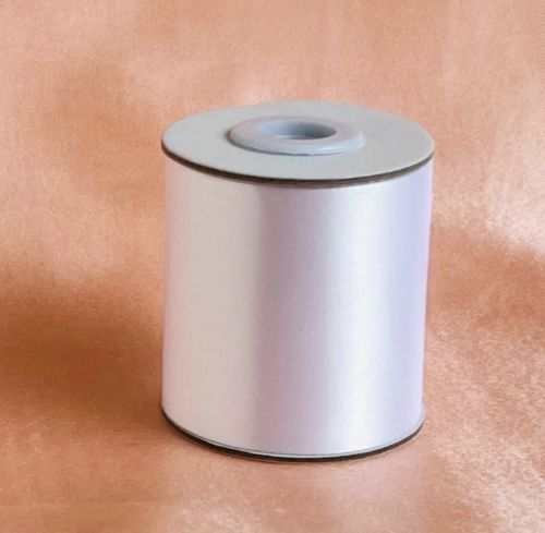 white satin material; 6cm wide ribbon; rolled on a spool; smooth glossy finish;