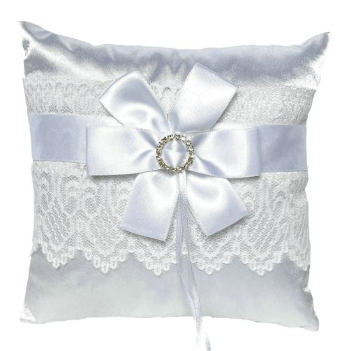 white satin square pillow; lace trim across the centre; white satin ribbon bow; jewel ring detail at bow centre;