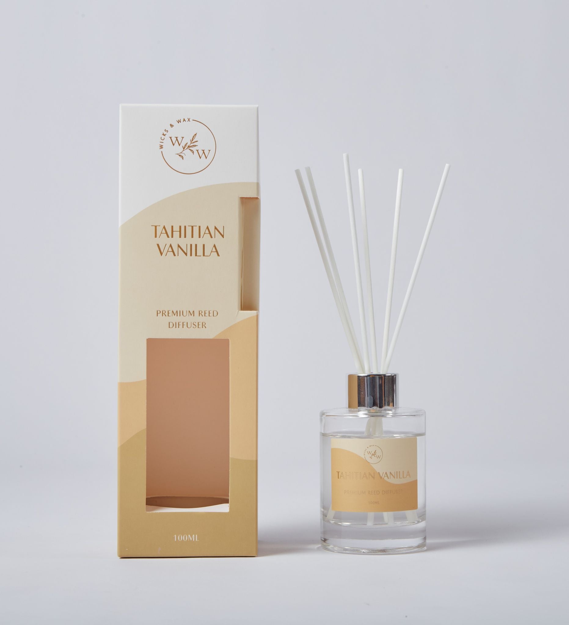 Clear glass bottle; Silver metal collar; Multiple white reed sticks; Tan and cream coloured packaging; Label with text 'Tahitian Vanilla';