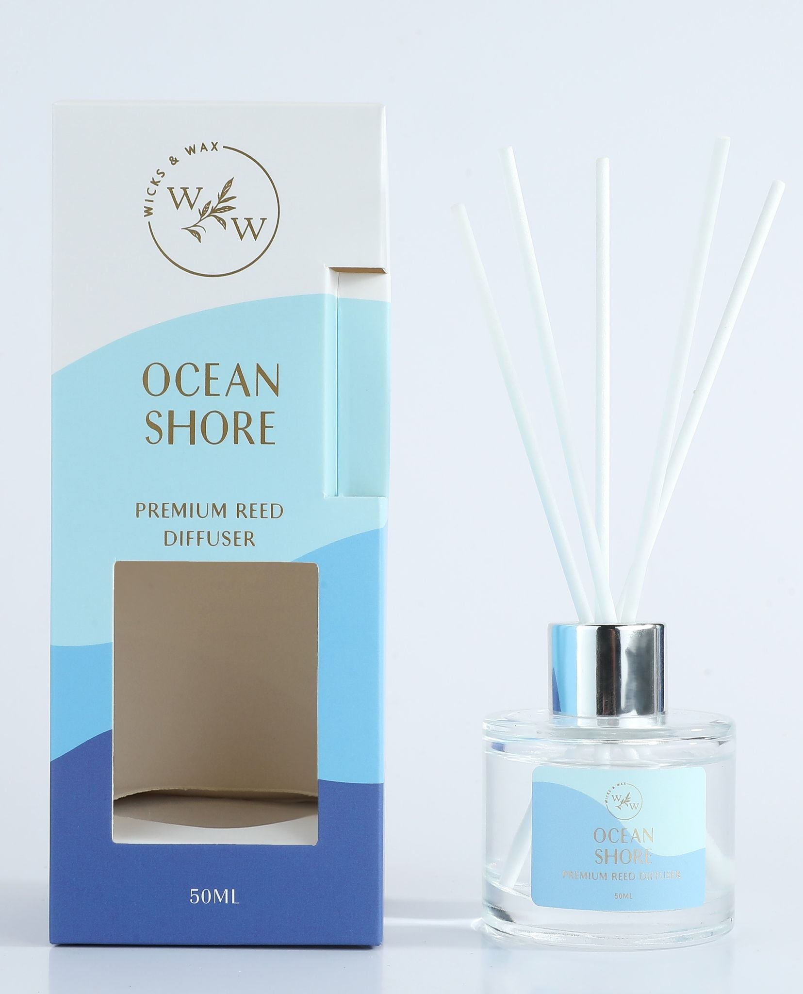 Clear glass round diffuser bottle; Silver metal ring collar; White reed sticks; Blue gradient box packaging; Gold foil text on box and label;