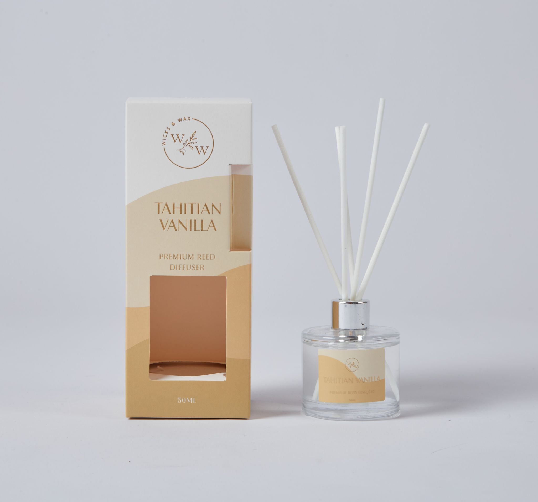 Clear round glass bottle with silver collar; White reed sticks inserted in diffuser; Beige and cream coloured packaging; Label on bottle matching packaging colour; Diffuser liquid visible inside bottle;