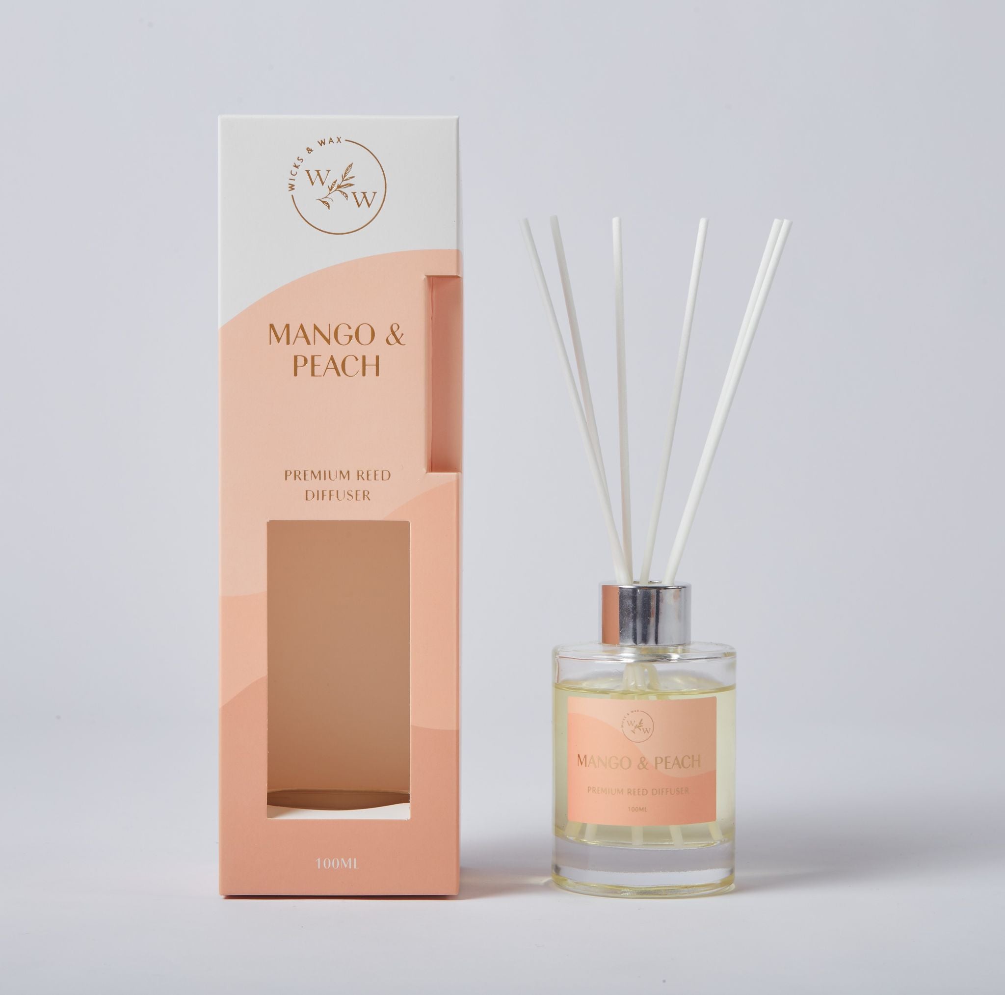 white reeds; clear glass diffuser bottle; silver metal collar; light peach label; peach and white packaging box;