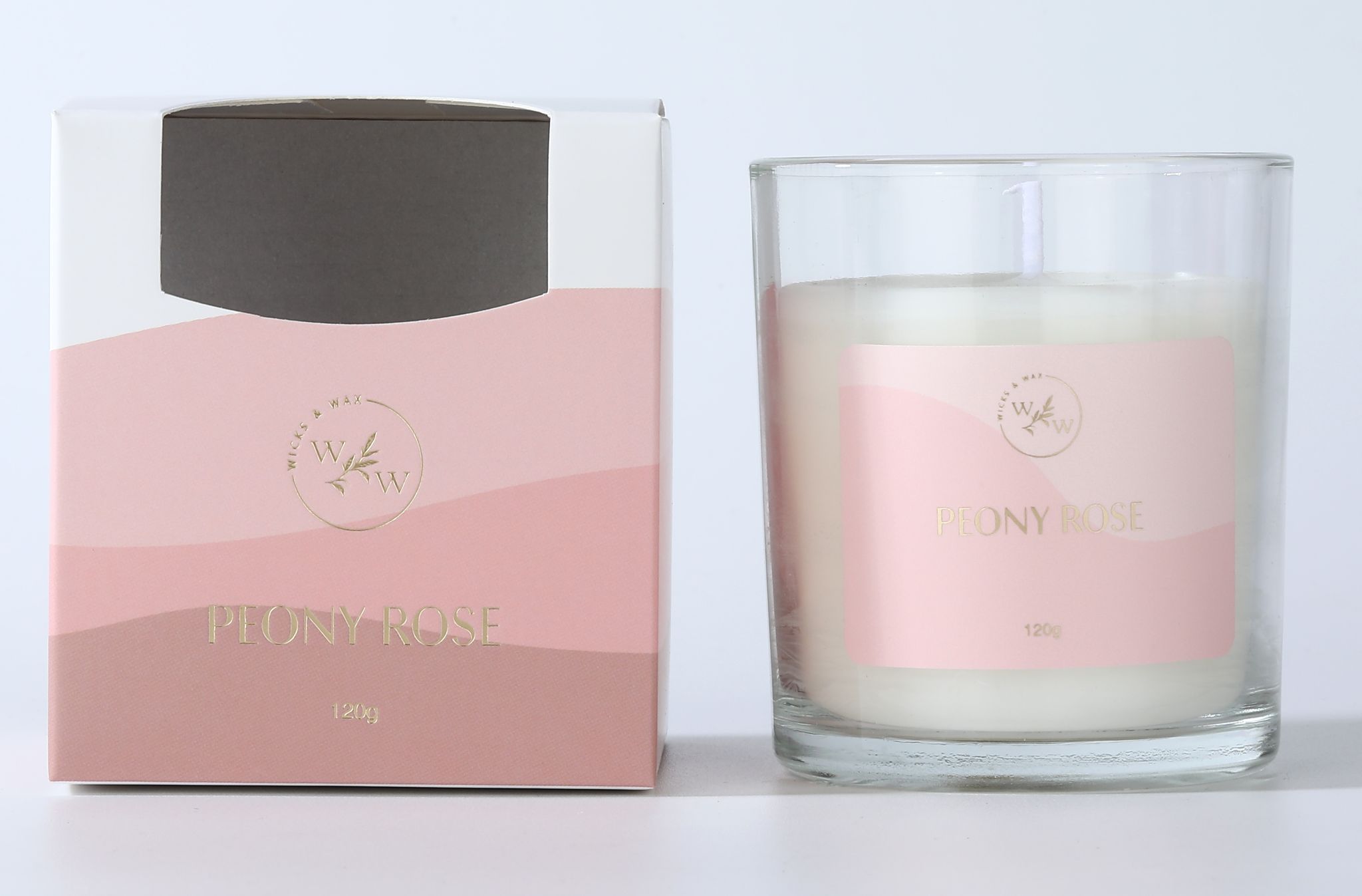 Clear glass container; Pink and white label with gold lettering; Box packaging with matching pink tones; White wax inside glass;