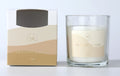 clear glass container; cream coloured wax; label with beige and light brown wavy design; gold embossed text on label; white wick;